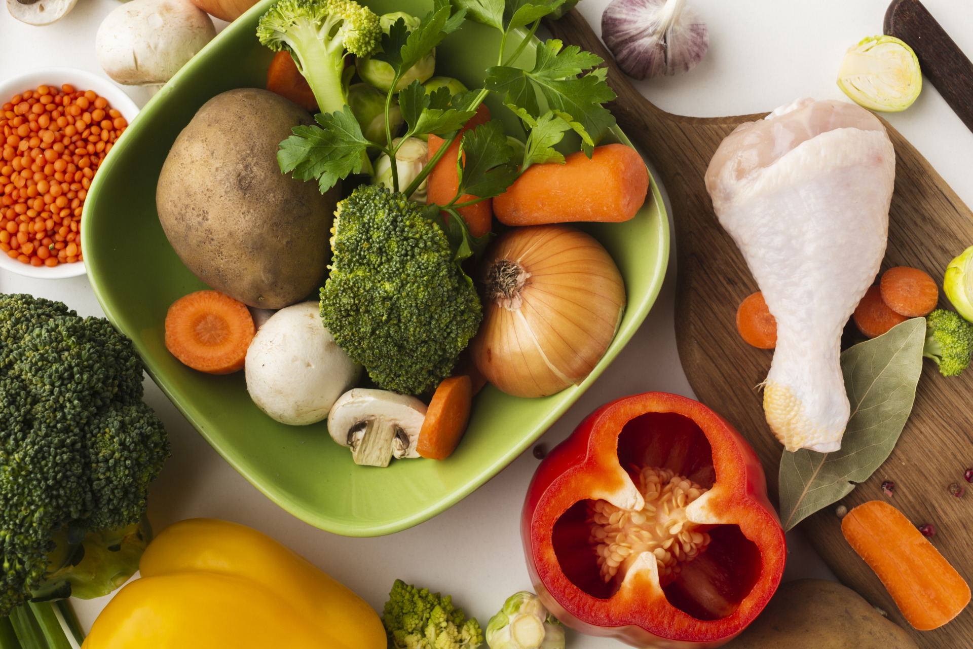 top view mix vegetables cutting board bowl with chicken drumstick