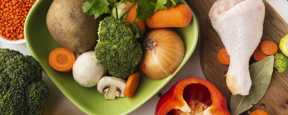 top view mix vegetables cutting board bowl with chicken drumstick