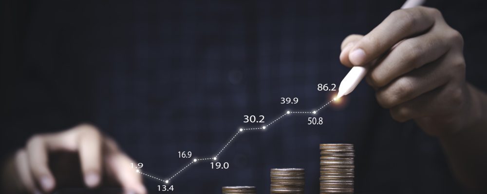 trader writing increasing graph coins stacking investment profit growth saving concept